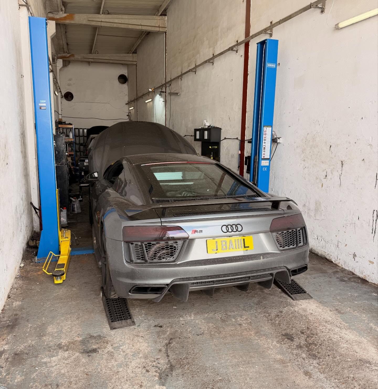 Silver Audi car on a lift in a garage